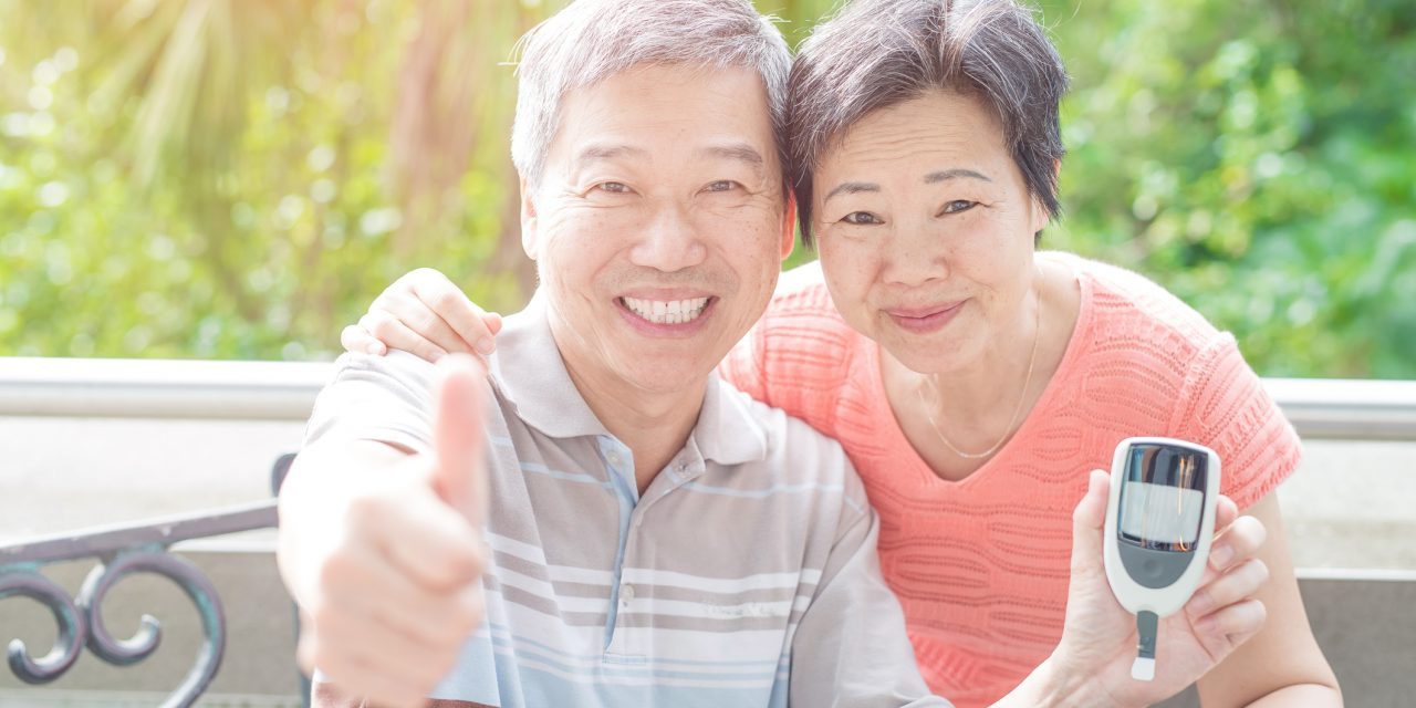 Smiling couple with blood glucose monitor